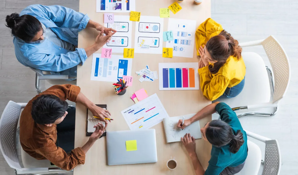 SEM: Cómo la IA y la personalización transformarán el futuro del marketing digital Top view ux developer and ui designer brainstorming - Keycode Agencia Digital