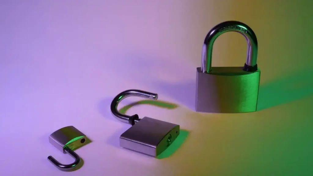 Ecommerce: How to build an online store with technology, user experience and artificial intelligence Candado metálico abierto y cerrado, simbolizando seguridad y confianza en e-commerce, con fondo iluminado en tonos verdes y morados.