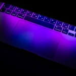 Keycode Digital Agency | We merge technology and imagination Semi-closed laptop radiating purple light Keycode