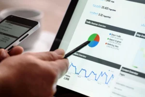 Persona analizando datos de tráfico en tablet con puntero digital, usando Google Trends para identificar tendencias SEO - Keycode Agencia Digital