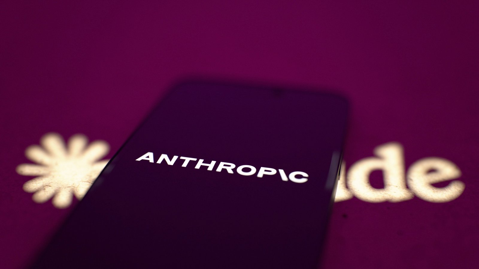 Teléfono con el logotipo de Anthropic frente al logotipo de Claude